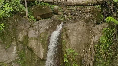 Tilt-down-shot-of-the-remote-Lumondo-waterfall,-deep-in-the-jungle-of-Alegria,-Surigao-Del-Norte,-Philippines-at-daytime