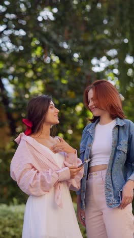 two young women having a conversation in a park