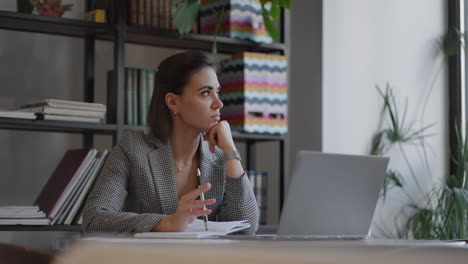 arabian hispanic woman working financial paperwork seated at workplace using laptop looks concentrated while makes task prepare check report having fruitful workday. student learning process concept