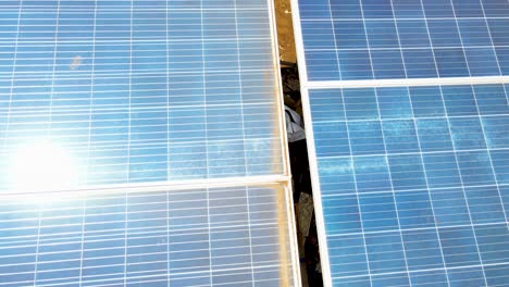 Aerial-drone-view-into-large-solar-panels-at-a-solar-farm-at-bright-sunset