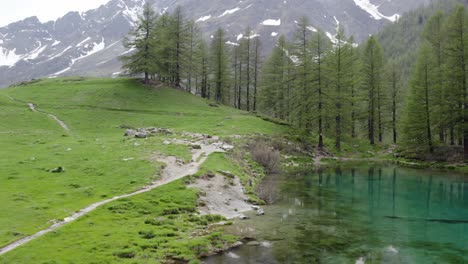 Ruta-De-Senderismo-A-Lo-Largo-De-La-Orilla-Del-Lago-Blu-Que-Refleja-Los-Abetos