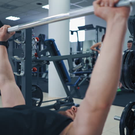 close-up of heavy barbell in man's hands during workout. muscular athlete lifting barbell up to build his arms muscles in sports club.