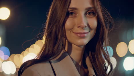 close-up portrait of a woman at night with blurred city lights