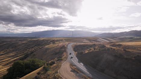 two cars leaving toward horizon on scenic alpine road