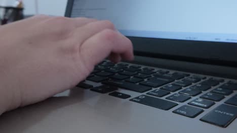 front view of hands typing on a laptop, engaged in writing or creating digital content
