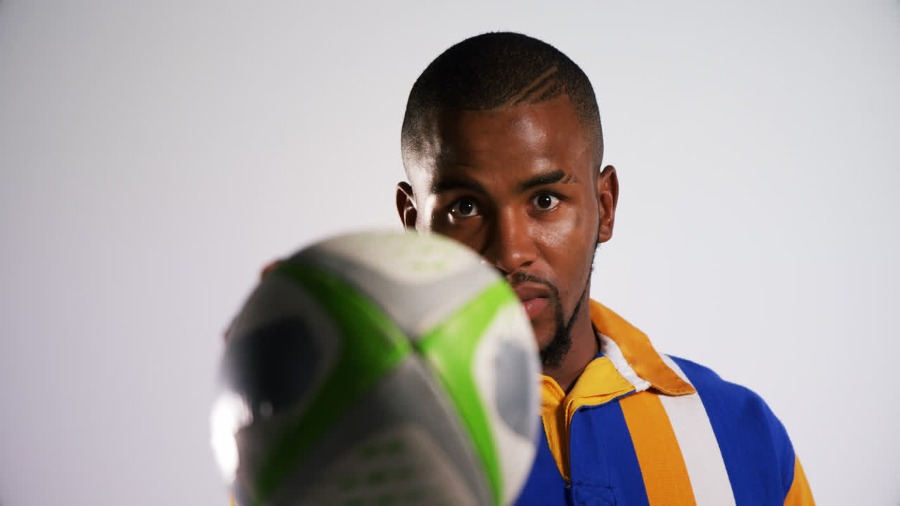 deportista profesional de rugby que muestra una pelota