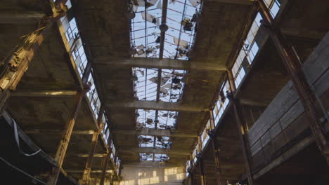 an industrial building with broken glass ceiling and destruction and decay all around