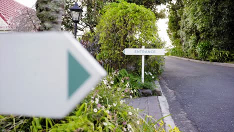 entrance sign in a distance with a blurred forground of another road sign