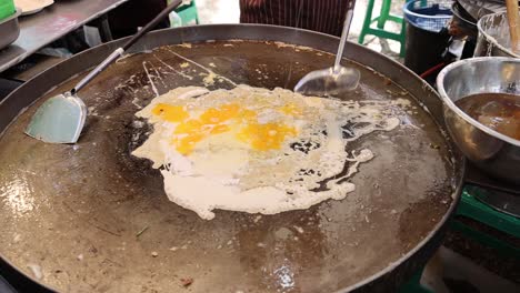 eggs frying and bubbling in a skillet.