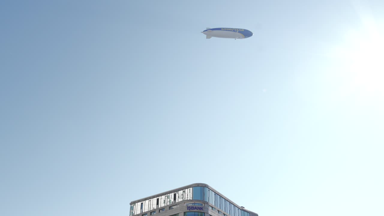 Goodyear Blimp Flying Over an Urban Building