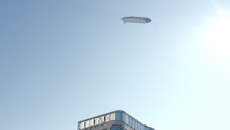 goodyear blimp flying over an urban building