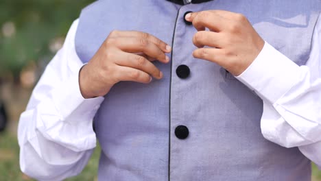 man buttoning his vest