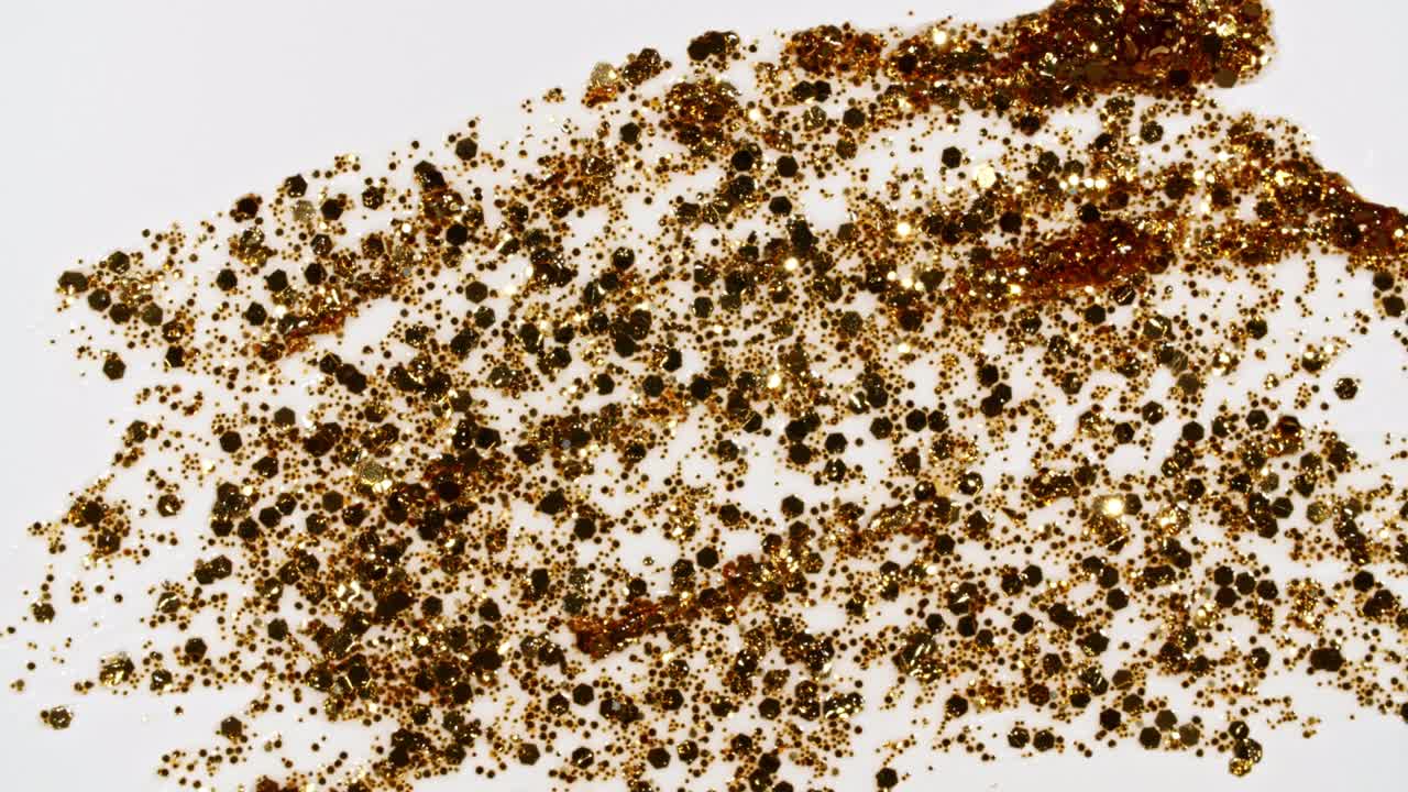 las pinceladas de pintura dorada aplicadas aisladas sobre un fondo blanco. la textura de la pintura dorada. el brillo, las estrellas, las chispas. la ilustración artística de textura dorada brillante. las manchas de cosméticos.