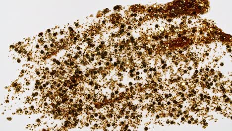 las pinceladas de pintura dorada aplicadas aisladas sobre un fondo blanco. la textura de la pintura dorada. el brillo, las estrellas, las chispas. la ilustración artística de textura dorada brillante. las manchas de cosméticos.