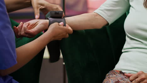 nurse using measurement device to check blood pressure on old people