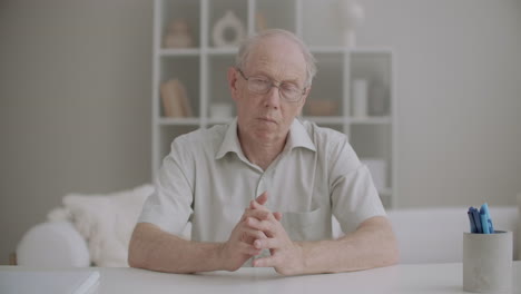 portrait of aged man looking at camera and nodding head listening person during video chatting medium shot