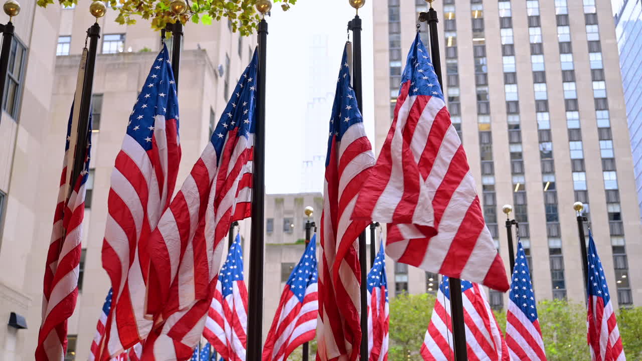 Pali con bandiere americane che sventolano al vento. Simboli patriottici degli Stati Uniti che decorano le strade di New York