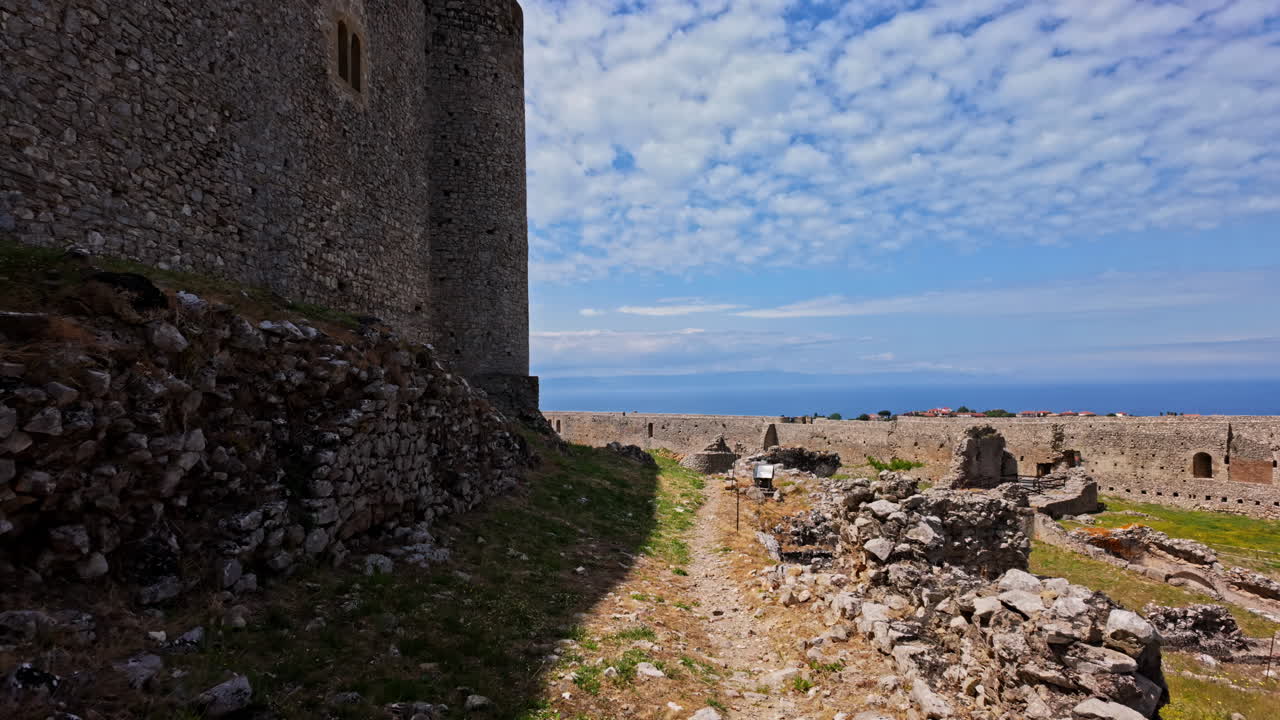 pov disparado mientras caminaba a lo largo de la pared exterior del castillo medieval de chlemoutsi, peloponeso, kyllini-andravida en grecia en un día soleado