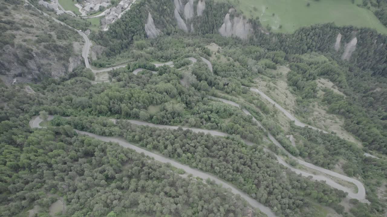 video panorámico con drone sobre el valle de aosta en san nicolás con la iglesia de fonfo y sobre un camino sinuoso