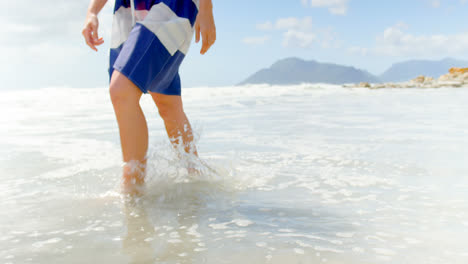 sección baja de la mujer caminando en la playa en un día soleado 4k