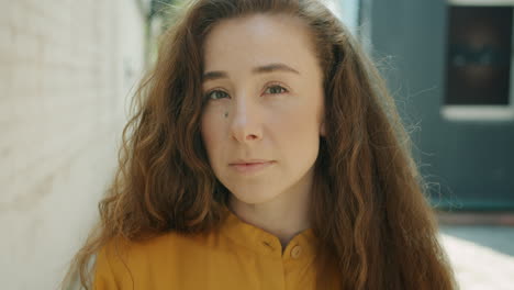 woman with curly hair in yellow shirt