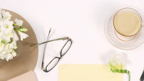 spoon, cup of tea, spectacles and white flowers