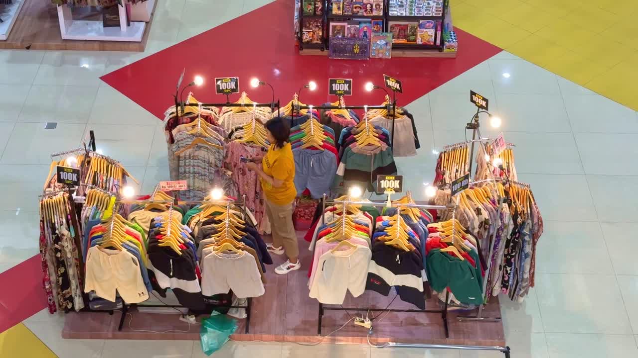 Clothes seller in the mall. Clothes hung on racks with price tags.