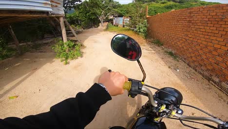 man driving motorcycle on road amid orchard in vinh hy, vietnam, pov