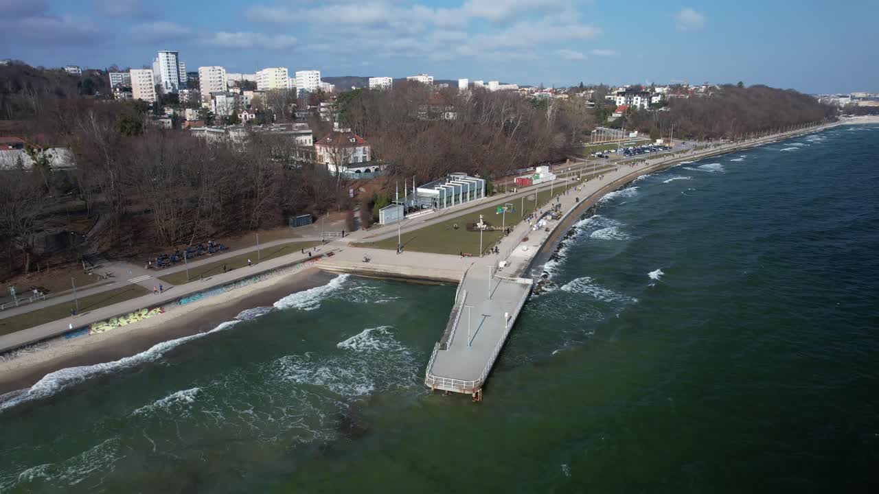 People running and cycling along Polish coastline. Sunny morning in Gdynia