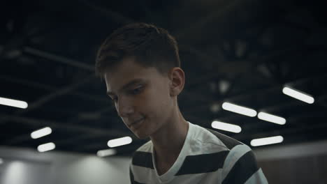 portrait focused schoolboy playing table football in school campus alone.