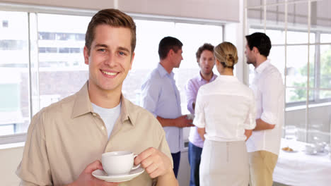 Attractive-young-businessman-posing-holding-a-mug-