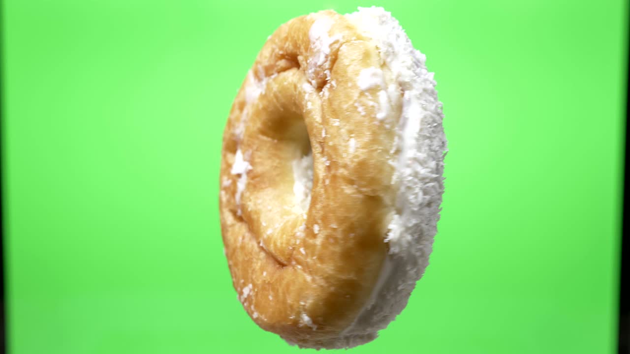 un disparo de deliciosa rosquilla blanca con papas fritas de coco girando en el fondo verde.