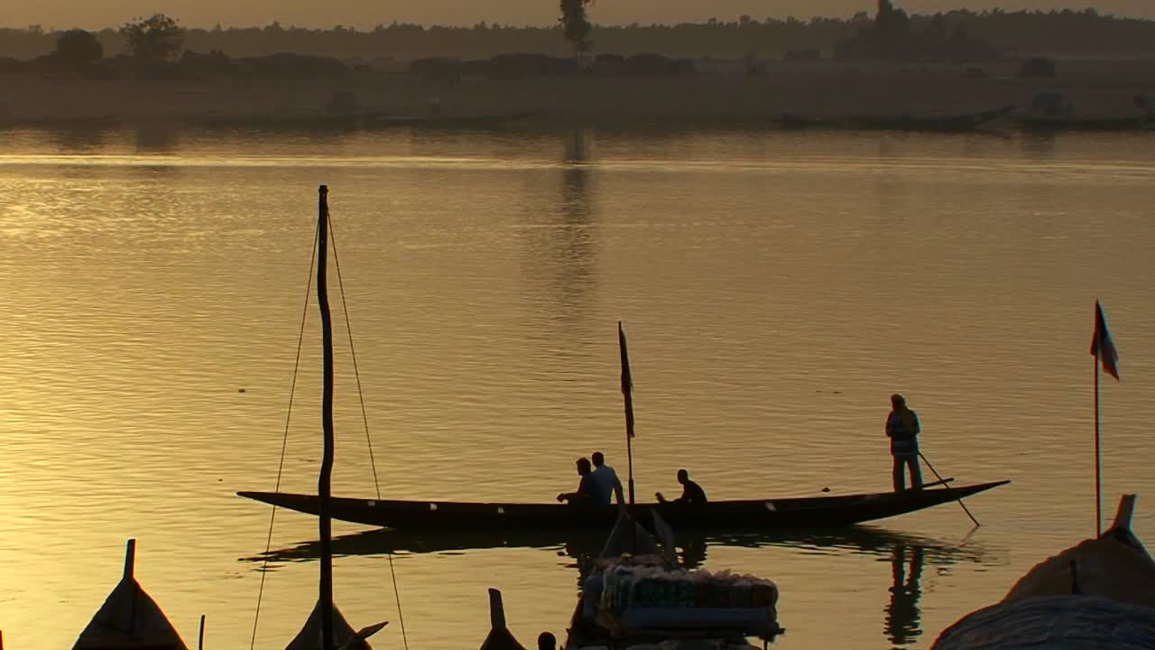 los barcos reman en el río níger en una hermosa luz dorada en mali áfrica