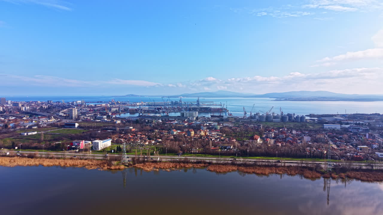 Vista della città con acqua e porto in lontananza, scattata con tempo sereno a mezzogiorno, che mostra barche ed edifici lungo la riva