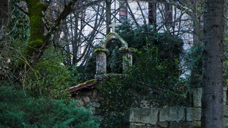 telefoto de la cruz de mampostería de piedra en la parte superior de la ermita de portovello, en las lagunas de ourense, españa