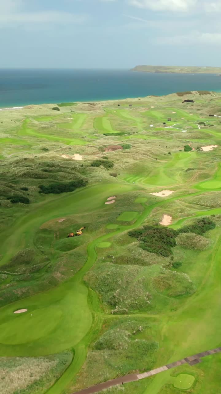Wide social ratio aerial video of Royal Portrush Golf Course in County Antrim, Northern Ireland, UK on a sunny day. Produced in 1080x1920 vertical ratio, 60FPS and with Rec709 color