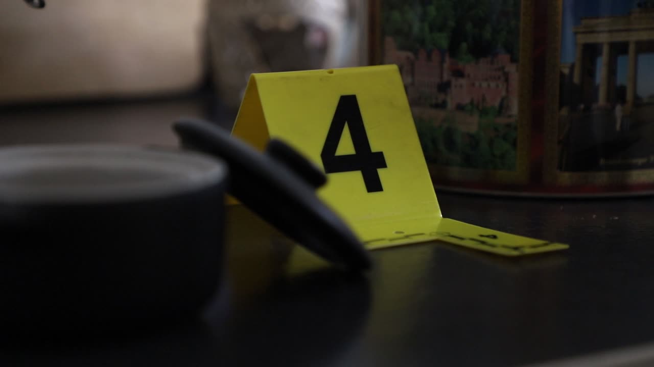 Crime Scene Unit officer numbering evidence in an apartment.