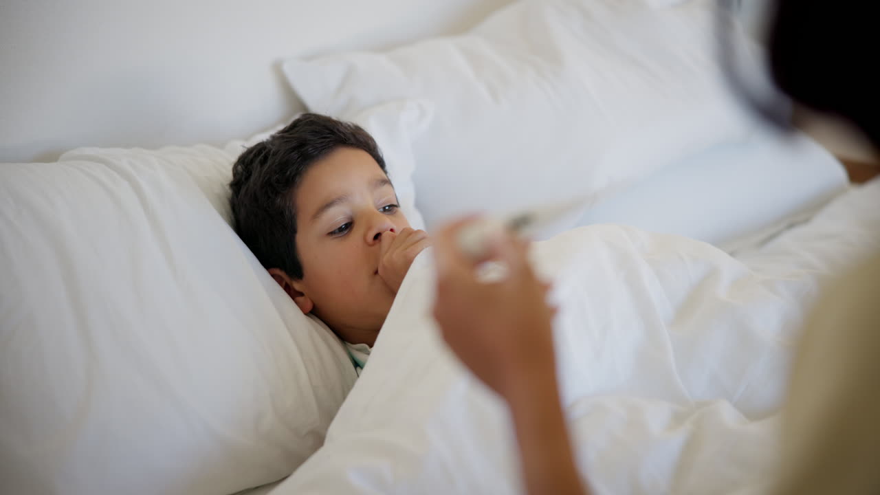 어머니가 아이의 체온을 확인하고 있습니다.