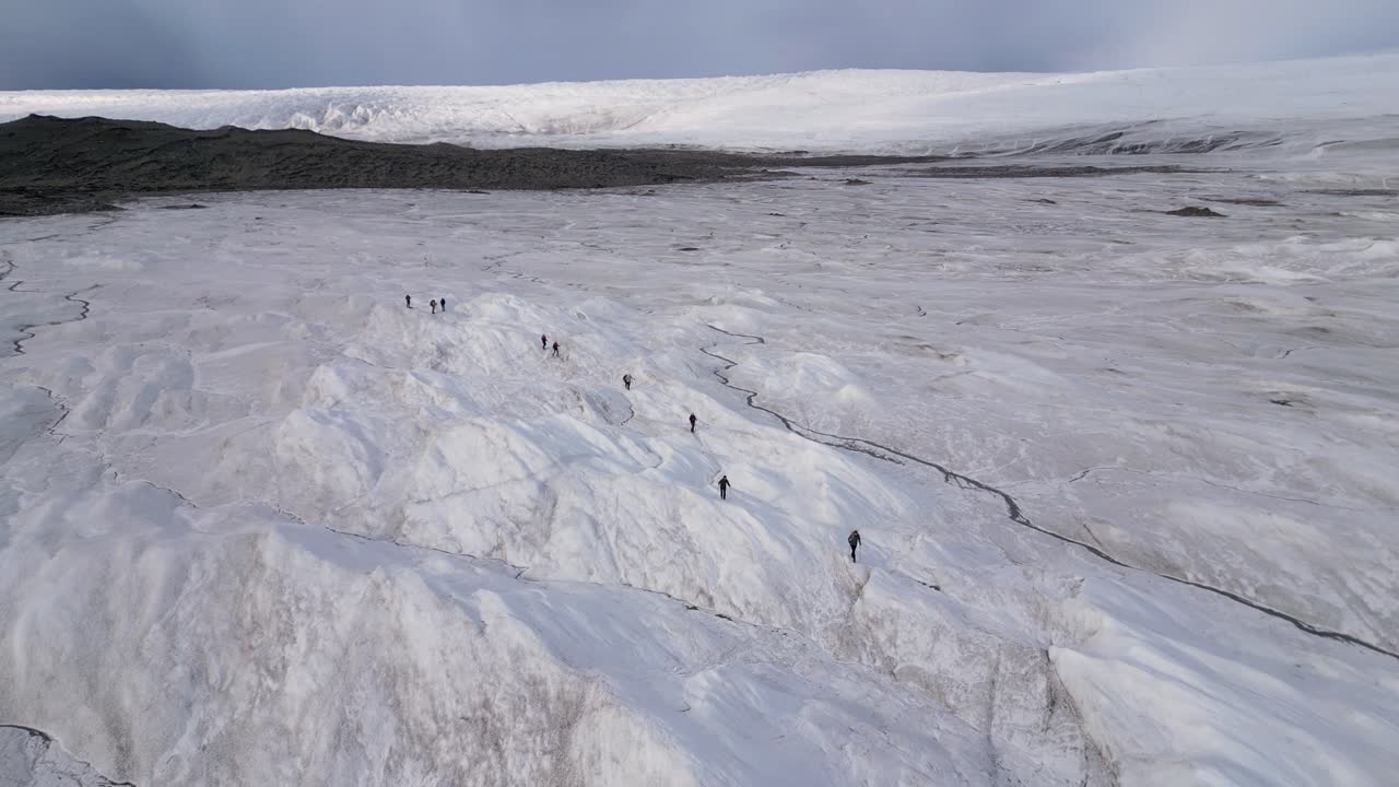 Ecotourism group hikes on vast Russell Glacier in Greenland arctic