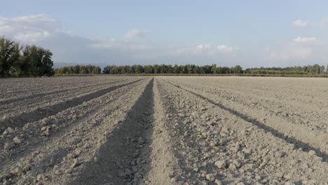 plowed field slide drone shot, ground in the sun ready for seeding