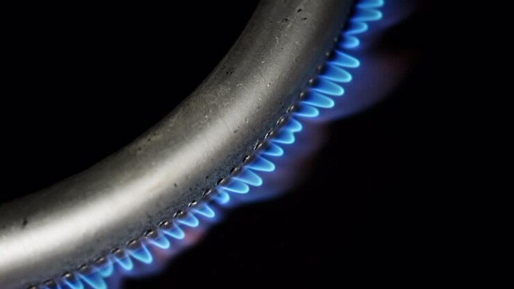 Burning gas burner in the oven close-up on a black background. 4k macro raw video.