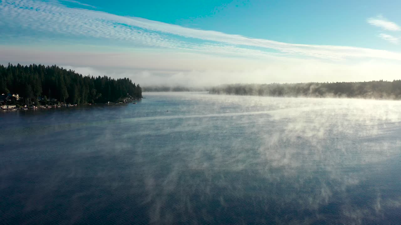 호수 안개는 워싱턴 숲에서 마법의 아침에 크리스탈 파란 물을 통해 신비하게 상승