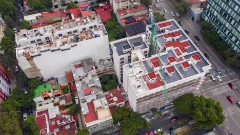 órbita aérea de edificios de apartamentos con grúa de construcción verde en la ciudad de méxico