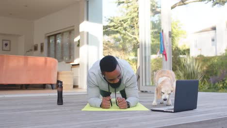 African-american-man-fitness-training-exercising-on-deck-in-sunny-garden,-slow-motion