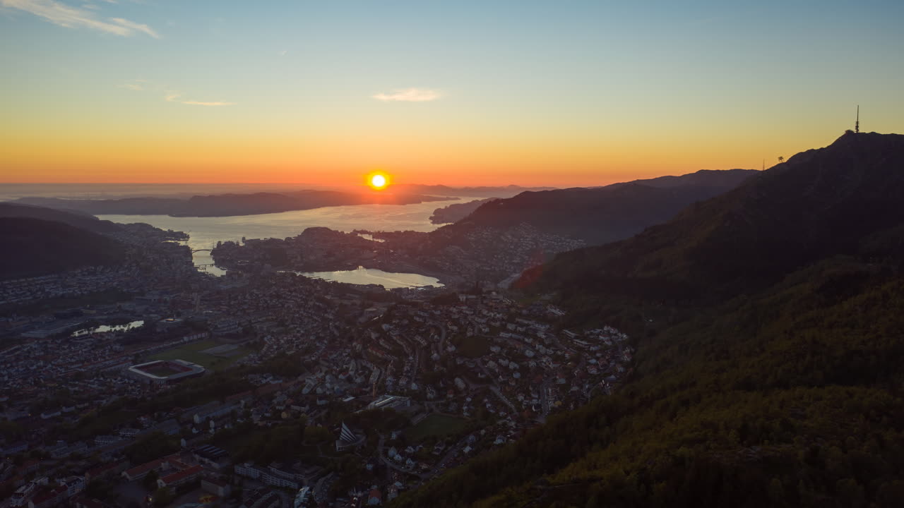 toma aérea sobre la montaña con una hermosa vista de la ciudad de bergen mientras el sol se pone