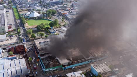 Aerial-view-around-a-factory-fire,-a-smoking-city-building---orbit,-drone-shot