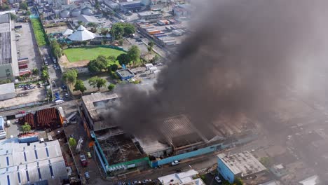 Vista-Aérea-Alrededor-De-Un-Incendio-De-Fábrica,-Un-Edificio-De-La-Ciudad-Humeante---órbita,-Disparo-De-Drones