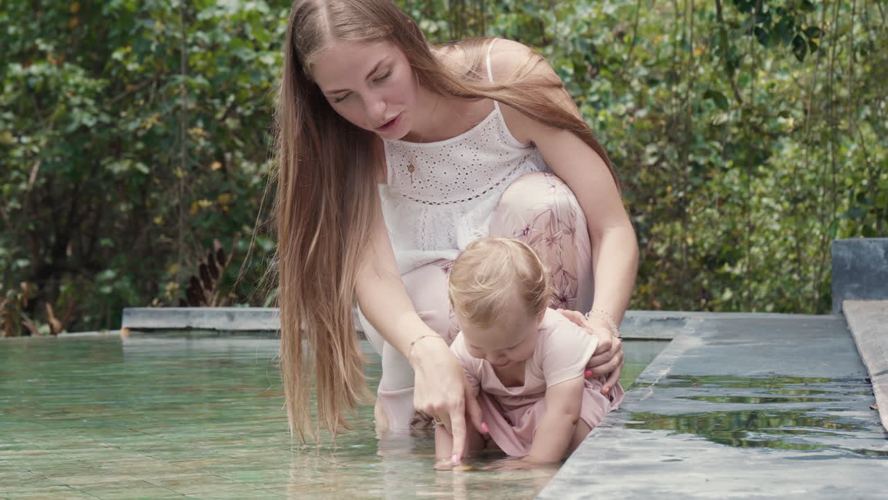 엄마와 딸이 연못에서 놀고 있다