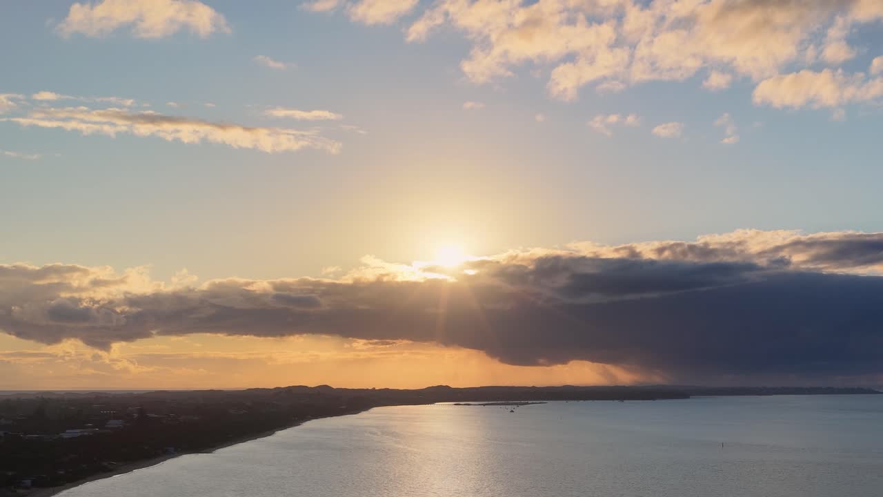 Golden sunset over Rye, Victoria coastline, clouds drifting, tranquil sea, wide aerial perspective