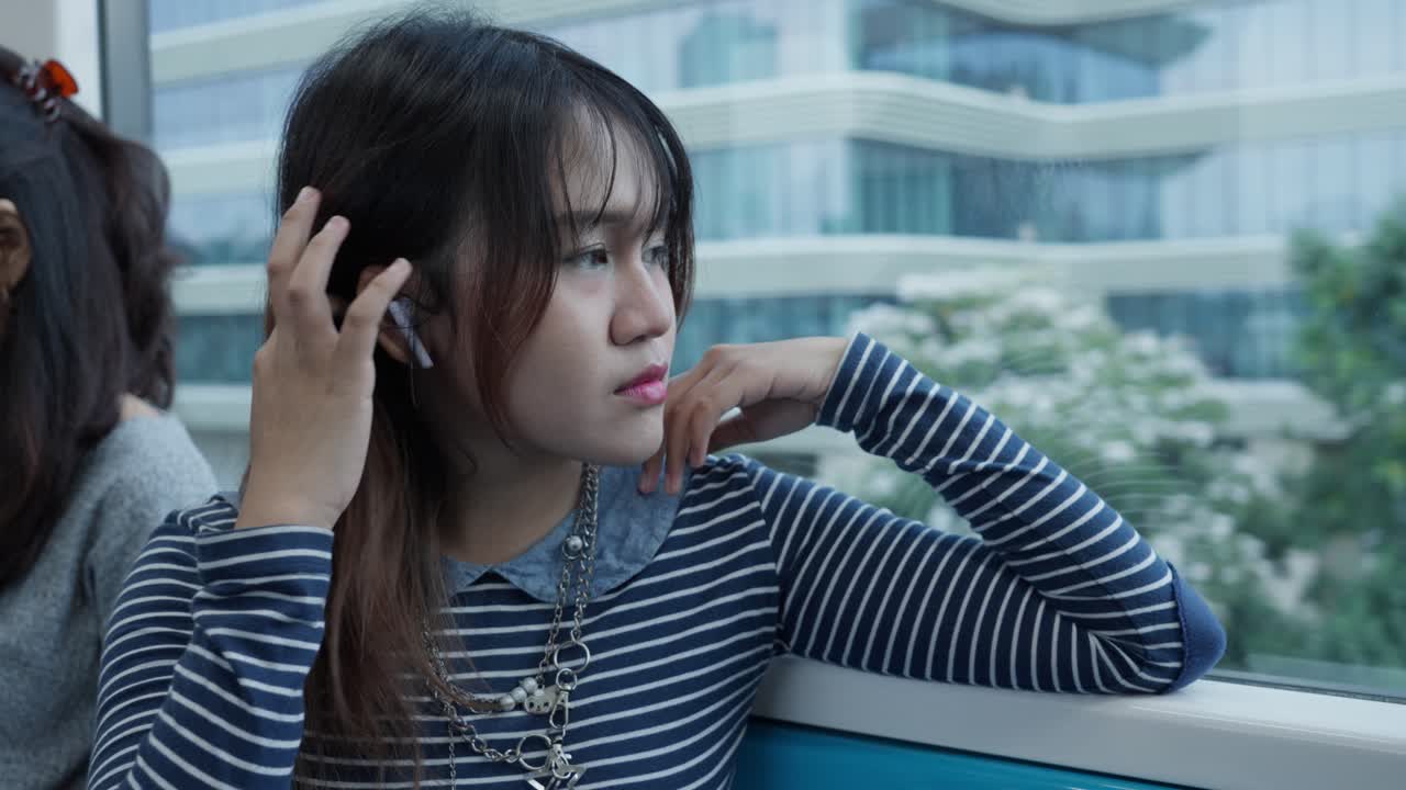 Young Indonesian Girl Passenger With Airpods On A Train. Close-up Shot